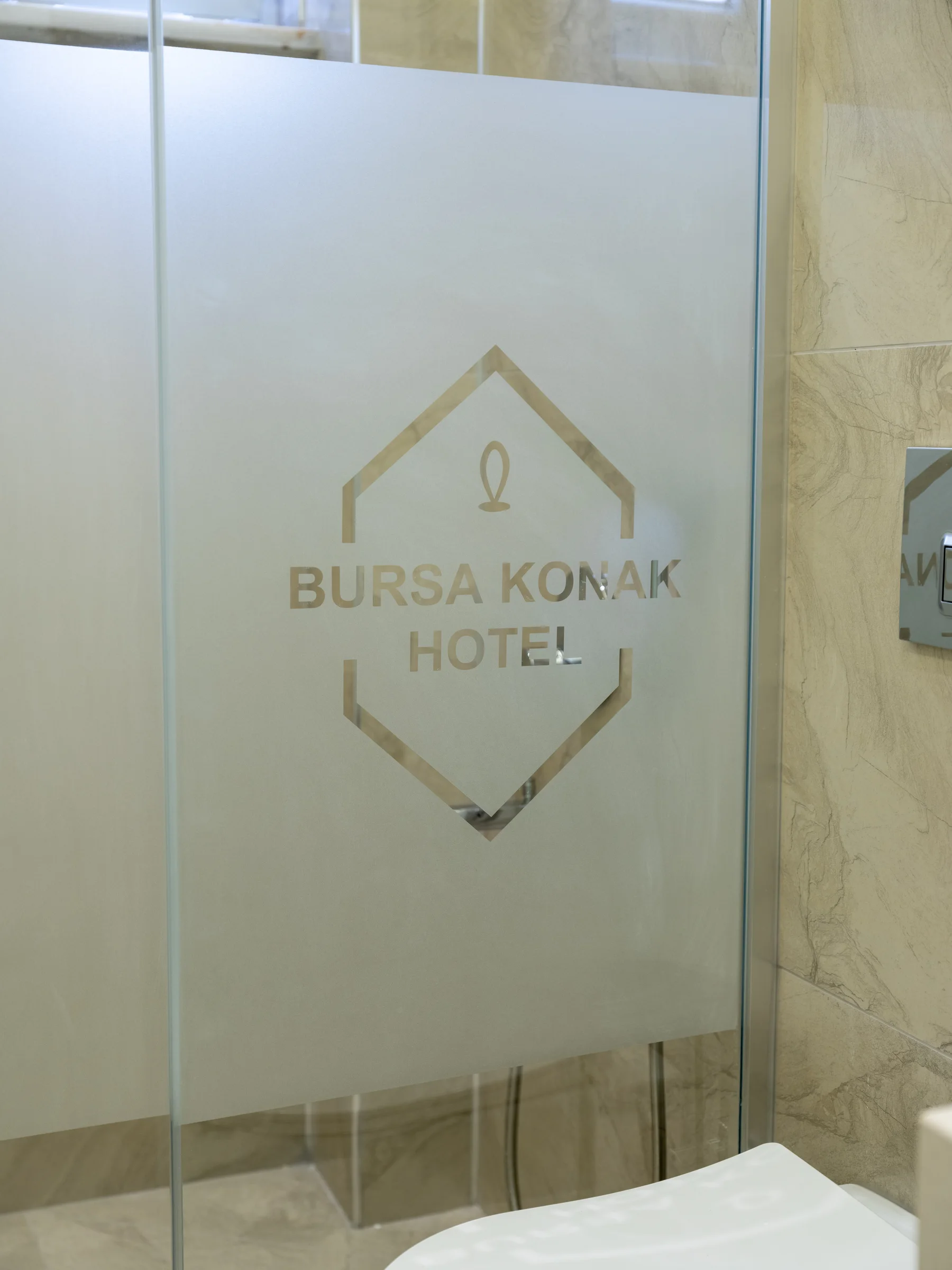 Banyoda cam duşakabin ve otel logosu