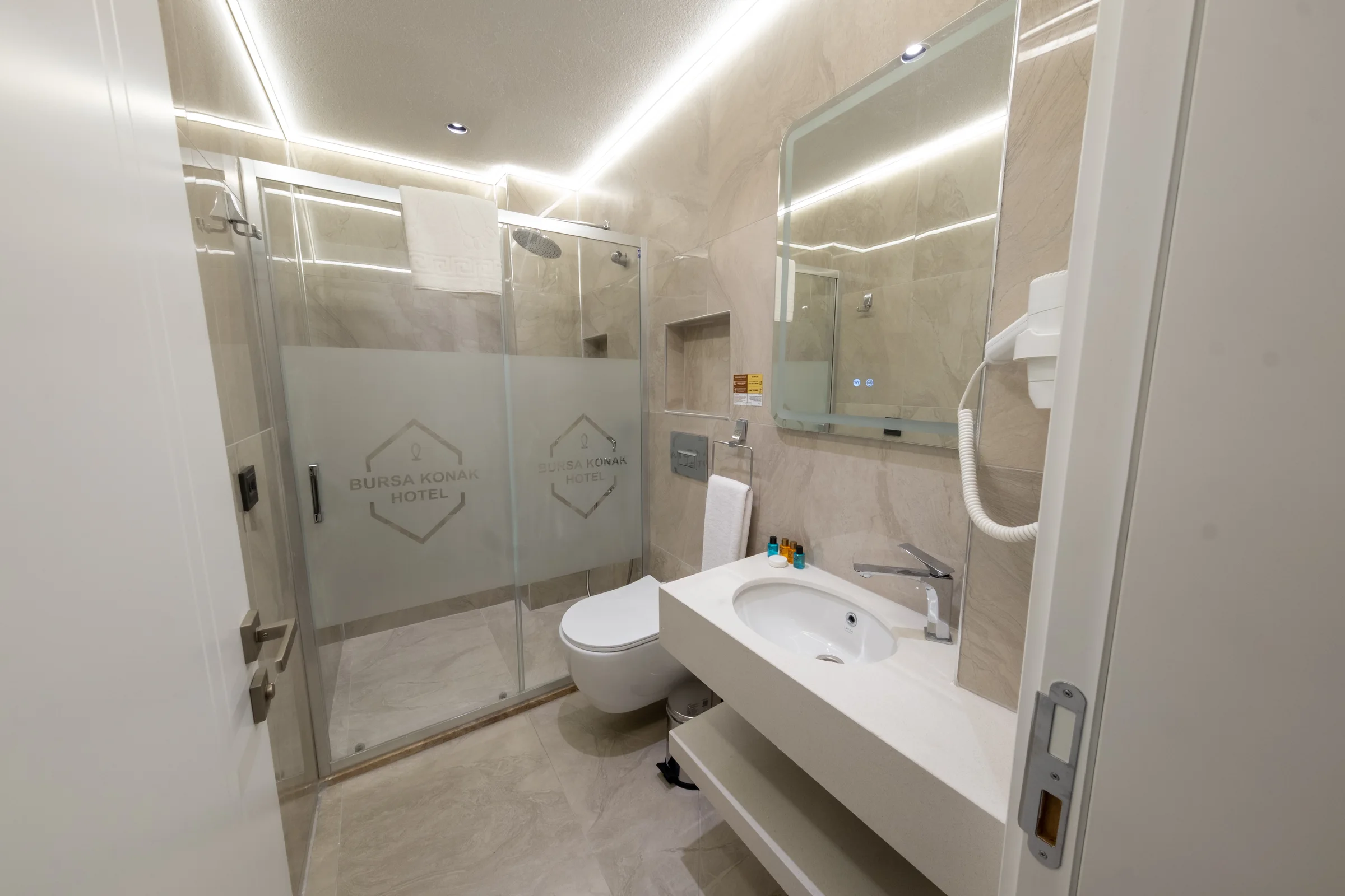 Triple oda banyosunda lavabo, ayna ve duş alanı