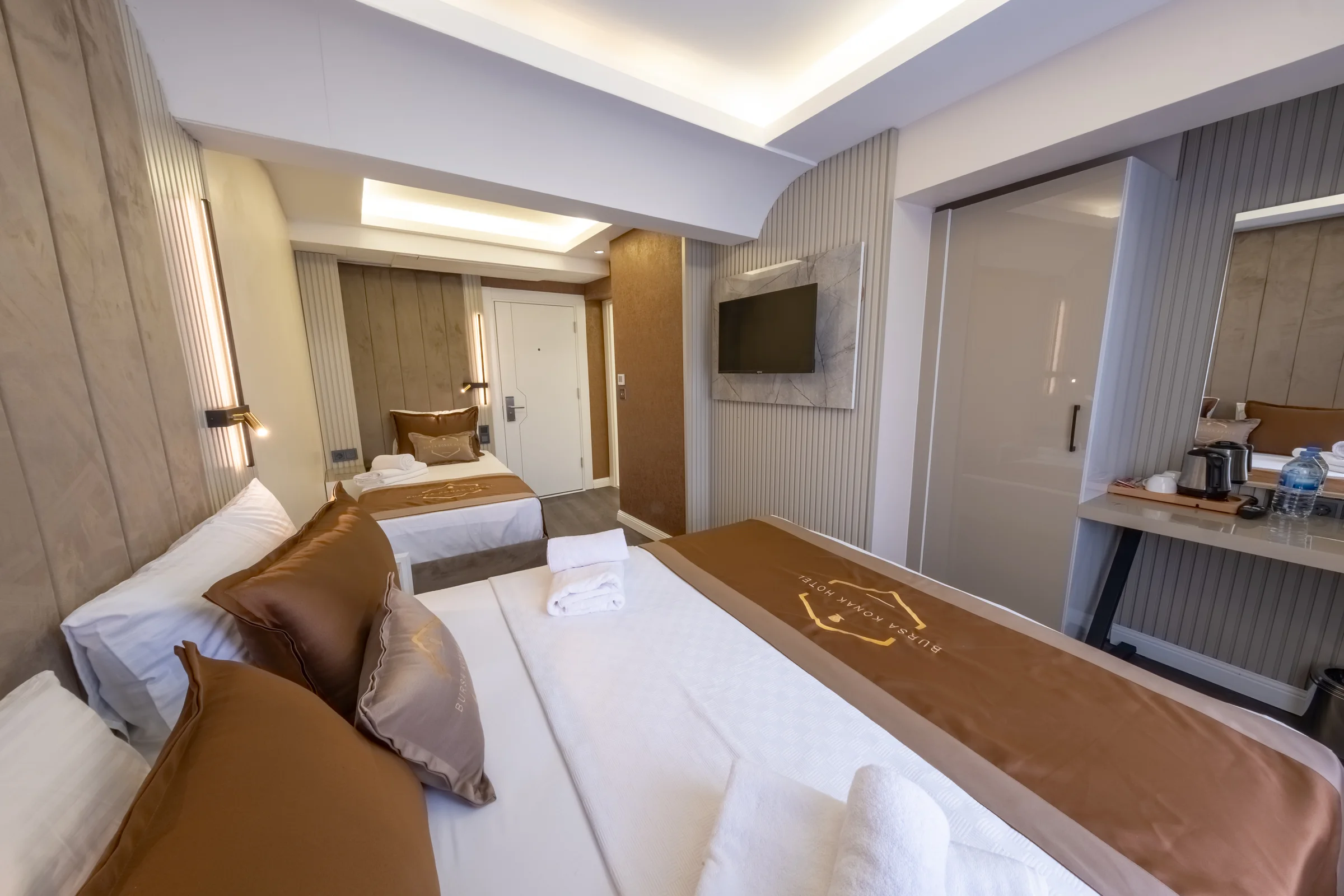 Triple odada yatak, televizyon ve gardırop görünümü